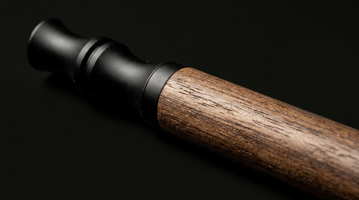 Macro detail of the Hale device: wood grain meeting the matte black mouthpiece